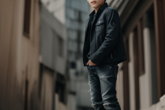 a-young-boy-in-a-suit-standing-on-a-sidewalk